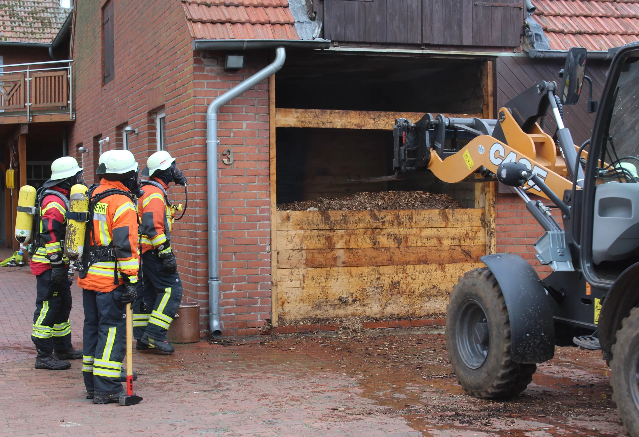 AGT stehen vor Spänebunker, Radlader im Einsatz.