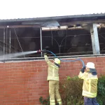 Einsatzkräfte löschen den gemeldeten Brand an einem Stall